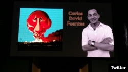 Carlos David Fuentes, junto a la caricatura premiada. (foto: Twitter/@andre_cath)