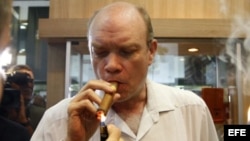 El ministro cubano de Inversión Extranjera, Rodrigo Malmierca (c), enciende un puro durante la inauguración de la feria comercial del XIV Festival del Habano, en La Habana.