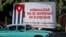 Un auto pasa junto a un cartel alusivo al embargo estadounidense a Cuba.