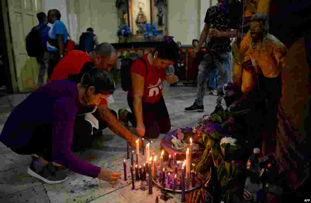 Creyentes ponen velas y flores a San Lázaro en la iglesia de El Rincón, en La Habana, para alabar al santo en su día. Yamil Lage/AFP