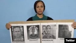 La esposa de José Daniel Ferrer, Nelva Ismarays Ortega, sostiene un cartel exigiendo su liberación.