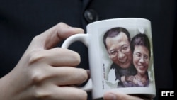 Un activista pro democrático muestra un retrato del disidente chino Liu Xiaobo y de su esposa Liu Xia.