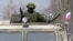 Un militar uniformado armado, fotografiado a bordo de un vehículo de infantería ruso "GAZ Tigr" en el exterior de un cuartel de una unidad del ejércitio ucraniano en la localidad de Perevalnoye, a las afueras de Simferopol, en la península de Crimea.