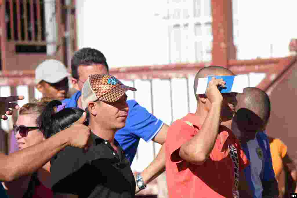 Decenas de cubanos hacen fila hoy, 10 de febrero de 2016, en la ciudad de David, capital de la provincia occidental panameña de Chiriquí, para comprar el boleto de avión, por 523,50 dólares cada uno, para viajar a México.