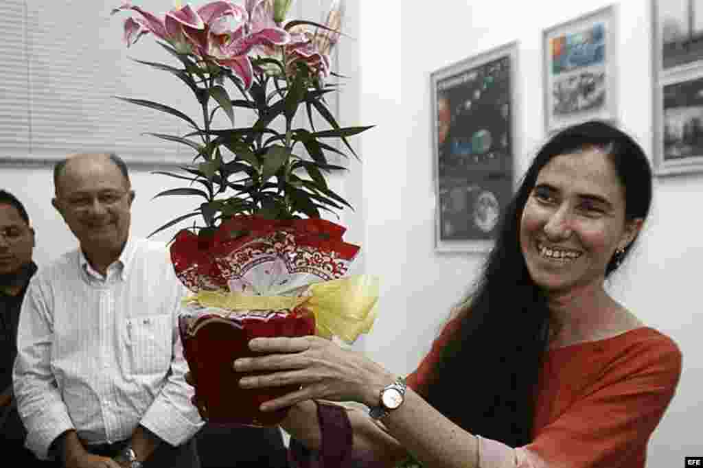 La cubana Yoani Sánchez (d), autora del blog "Generación Y", sonríe con un regalo recibido durante su primera jornada de visita a Brasil hoy, lunes 18 de febrero de 2013, en Feira de Santana.