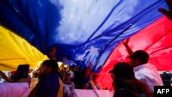 Manifestantes despliegan una bandera venezolana gigante en México DF, durante una marcha de apoyo a los resultados electorales de oposición de ese país en los comicios presidenciales.