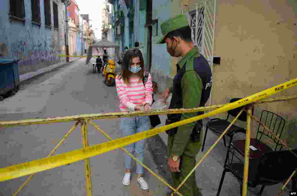 Un policía vigila la entrada a un barrio con brote de coronavirus en La Habana. (YAMIL LAGE / AFP)