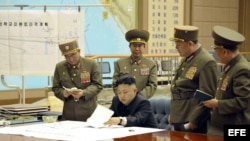 Foto de archivo del dictador norcoreano, Kim Jong-un (c) mientras mantiene un gabinete de crisis con varios oficiales norcoreanos para ordenar que esté listo el arsenal de cohetes.