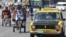 Mientras algunas personas se movilizan por las calles de La Habana en Bicitaxis (i) los taxistas intentan recuperar el terreno perdido...