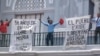 Opositores enarbolan carteles en contra del Gobierno cubano en la catedral de Santiago de Cuba.