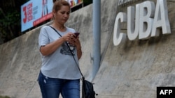Una mujer se conecta a internet desde su celular en una calle de La Habana, Cuba.