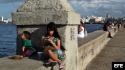 Una joven se conecta a internet en el muro del Malecón, en La Habana. (Archivo)