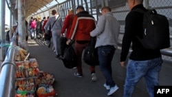 Un grupo de migrantes cubanos cruzan el Puente Internacional Paso del Norte hacia Estados Unidos para solicitar asilo político.