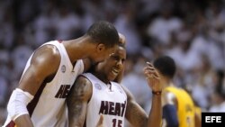 Chris Bosh (i) de los Miami Heat habla con Mario Chalmers.