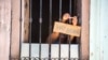 FOTO ARCHIVO. Un cubana anuncia con un cartel la venta de bocaditos desde su ventana. (AP Photo/Desmond Boylan)
