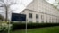 Department of State sign in front of Harry S Truman Department of State building in Washington, DC on an overcast day.