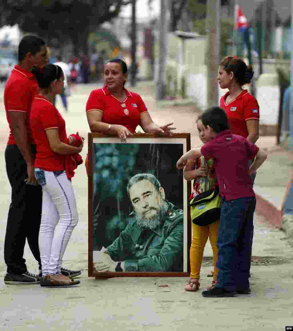 Un grupo de personas llevan un cuadro con la imagen de Fidel Catro hoy, viernes 2 de diciembre de 2016, mientras esperan la llegada de la caravana que traslada las cenizas del fallecido líder de la revolución cubana Fidel Castro, en Holguín, a 800km de L