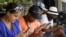 Un grupo de jóvenes navegan por internet desde sus dispositivos móviles en una de las zonas habilitadas con Wi-Fi en La Habana (3 de julio, 2015).