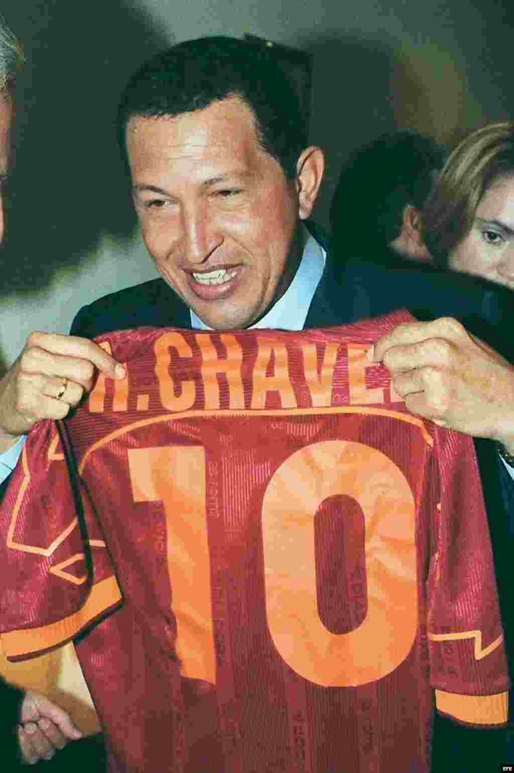 El presidente de Venezuela, Hugo Chávez, muestra una camiseta de béisbol con su nombre, que le entregó un compatriota a su llegada a la sede de la CEOE en octubre de 1999, donde asistió a una reunión con empresarios españoles y venezolanos.