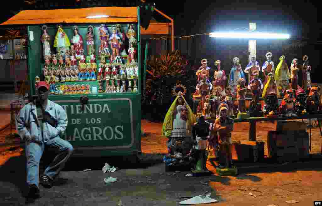 Un hombre vende imágenes de la virgen en el Santuario de "El Rincón", en la Habana (Cuba). Manufacturas de piedra, yeso y cemento.
