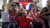 Simpatizantes del gobierno cubano gritan consignas revolucionarias frente al grupo de mujeres Las Damas de Blanco.