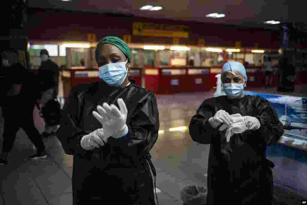 Trabajadores sanitarios se preparan para tomar muestras para exámenes de coronavirus a los pasajeros en el aeropuerto José Martí de La Habana.