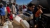 La gente hace fila en un camión cisterna que distribuye agua potable en medio de las secuelas del huracán Ian en La Coloma, provincia de Pinar del Río, Cuba, el 5 de octubre de 2022. (AP Foto/Ramón Espinosa)