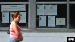 Una mujer camina junto a carteles alusivos a las elecciones municipales en Cuba. (Archivo)