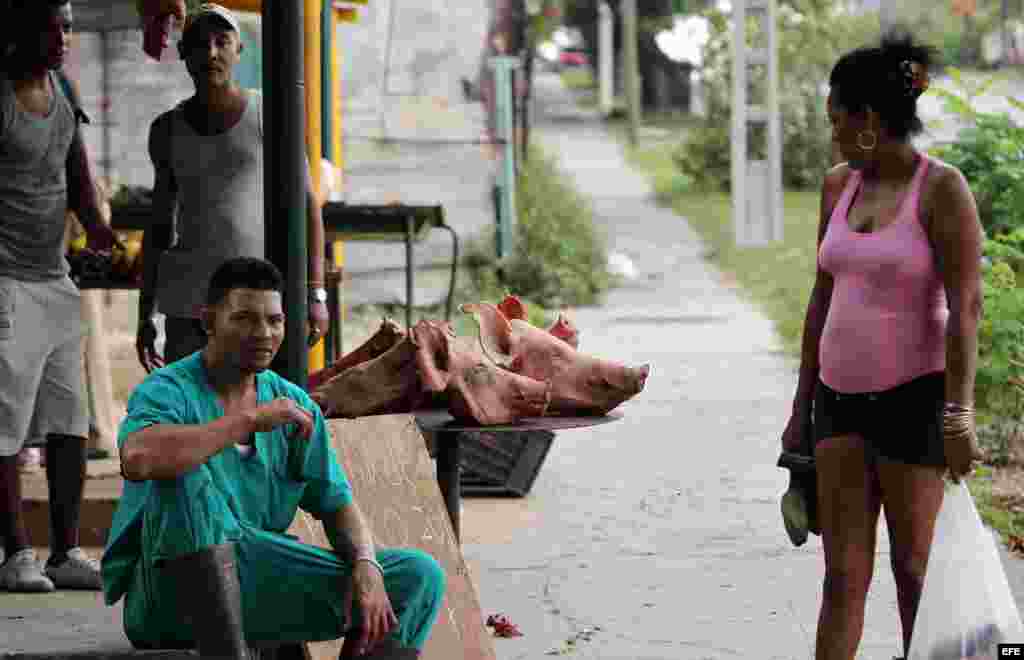 Un carnicero vende cabezas de cerdo el miércoles 31 de diciembre de 2014, en La Habana (Cuba).