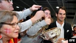 El tenista suizo Roger Federer (d) posa con los fans que le aguardaban a su llegada al aeropuerto de Zúrich (Suiza), el 31 de enero de 2017.