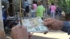 Un hombre muestra un peso convertible cubano y un dólar estadounidense frente a una oficina de la Western Union en La Habana.