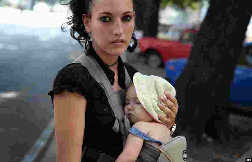 Una mujer carga a su pequeño hijo en La Habana (Cuba)agosto de 2014. Para el año 2030 o quizás antes la población de Cuba baje de 11 millones de habitantes, de un aproximado actual de 11 millones 167 mil.