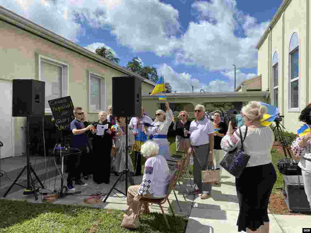 Ucranianos cantan el himno nacional en la manifestación contra la invasión rusa.