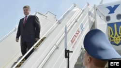 El presidente ucraniano, Petro Poroshenko (i), baja del avión a su llegada al aeropuerto nacional de Minsk (Bielorrusia), el martes 26 de agosto de 2014.