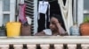 Una mujer mira a la calle desde su balcón en La Habana.