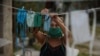 Una mujer del Mariel tiende nasobucos de tela el jueves luego de lavarlos (Foto: Yamil Lage/AFP).