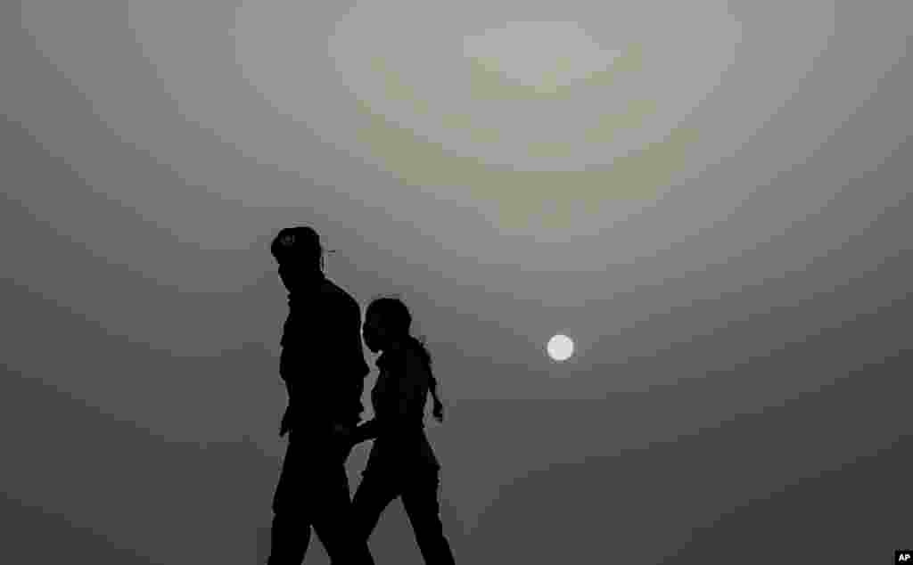 Policías usan máscaras por el coronavirus y para protegerse del polvo del Sahara, que cubre la capital cubana. (AP/Ramon Espinosa)