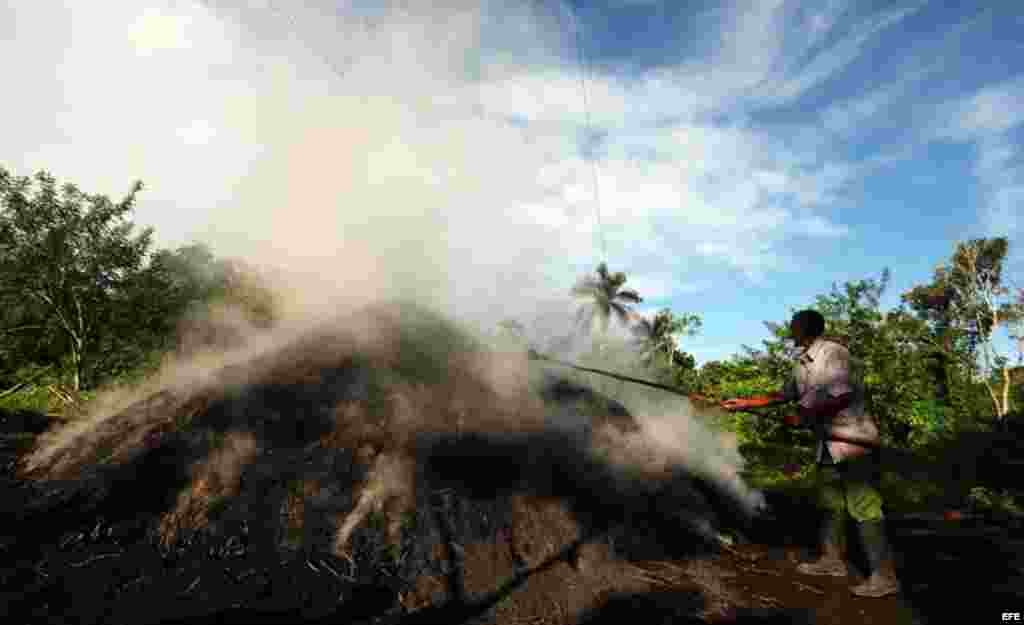 Horno humeante, atendido por un carbonero en Nueva paz, La Habana.