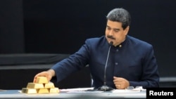 Nicolás Maduro toca una barra de oro mientras se dirige a los ministros responsables del sector económico en el Palacio de Miraflores.