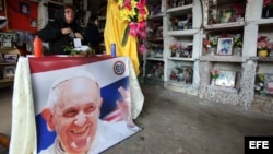 Una mujer prepara un altar en una mesa con una imagen del papa Francisco hoy, jueves 9 de julio de 2015, en la sede que fuera del supermercado Ycuá Bolaños en Asunción (Paraguay).