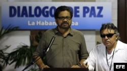 El jefe del equipo negociador de las FARC en los diálogos de paz, Luciano Marín Arango (c), alias Iván Márquez, acompañado de Seuxis Paucias Hernández Solarte (d), alias Jesús Sántrich, lee un comunicado a la prensa en el Palacio de Convenciones de La Habana (Cuba).