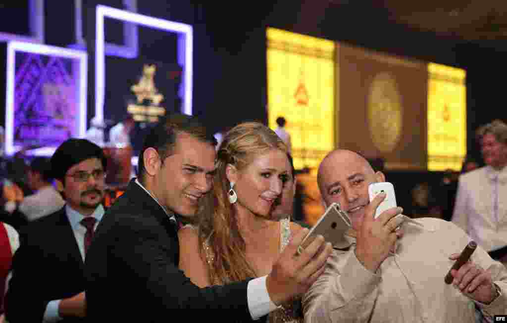 La celebridad estadounidense Paris Hilton (c), heredera del imperio hotelero de su apellido, posa con dos asistentes a su llegada a la cena de gala que cerró el XVII Festival Internacional del Habano. 
