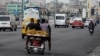Tres hombres transportan plátanos en un bicitaxi, en La Habana, el 18 de julio de 2023. (Photo by YAMIL LAGE / AFP)