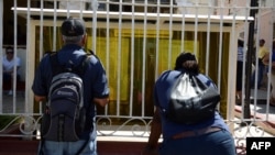 Cubanos leen información en la Oficina de Inmigración y Extranjería. Foto Archivo.