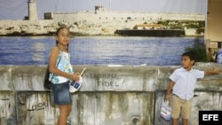 Dos niños delante de una replica del "Malecon" de la Habana durante el evento "Cuba Nostalgia".