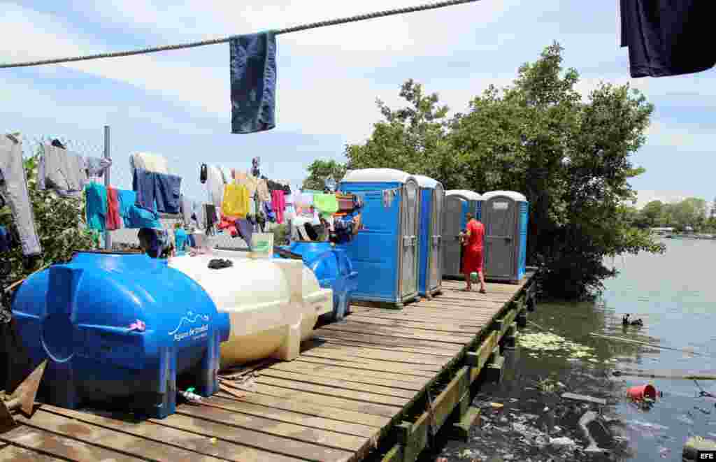 Fotografía del 31 de julio de 2016 de ciudadanos cubanos en tránsito en la población de Turbo (Colombia). Hacinados en improvisados albergues en la localidad colombiana de Turbo unos 2.000 cubanos, hombres mujeres y niños, pasan los días esperando notici