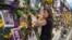 Gini Gonte visita el miércoles 7 de julio de 2021 un muro con fotografías y flores para recordar a las víctimas del desplome del edificio residencial Champlain Towers South, en Surfside, Florida. (Al Diaz/Miami Herald vía AP)