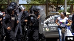 Miembros de la policía nacional bloquean la marcha opositora.