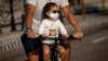Una niña transportada en bicicleta usa un nasobuco para evitar el contagio del coronavirus, en La Habana, Cuba. AP Photo/Ramon Espinosa
